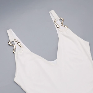 Detailed close-up of white V-neck strap dress with elegant gold metal buckle accent