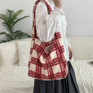 Model wearing a red and white checkered plush tote bag in a cozy home setting