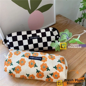 Close-up of corduroy pencil case with floral pattern and merciparis woven label