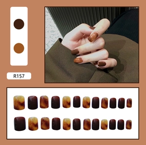 Detail of amber tortoiseshell and solid brown press-on nails in short square shape