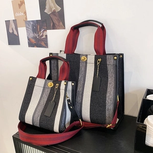 Detailed view of color-block canvas tote bags with red handles on a modern shelf