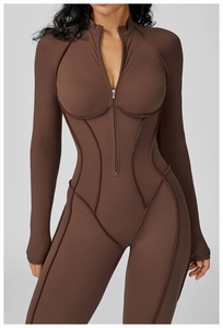 Dettaglio del body sportivo marrone con cuciture a contrasto e colletto con zip