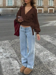Close-up of deep brown V-neck knit sweater with side lace-up detail and soft texture