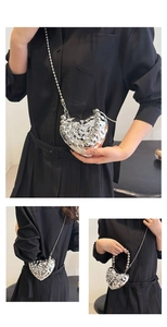 Detail of silver heart-shaped evening bag with liquid metal lava texture and beaded chain