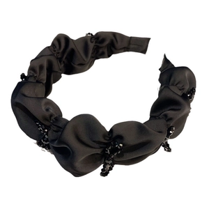 Elegant pleated black fabric headband with crystal beaded accents on a clean white background