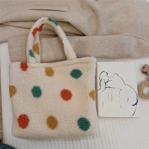 Detail of soft white faux shearling tote bag with colorful plush polka dot patterns