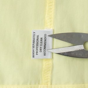 Close-up of washing instructions on label for yellow strap and skirt summer set
