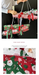 Detail of Christmas wrapping paper with Santa patterns, pearl chain, and festive ribbons