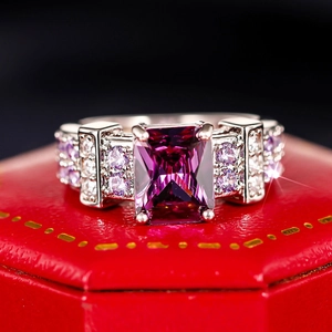 Macro shot of silver ring with rectangle purple gemstone and pavé accents in a red box