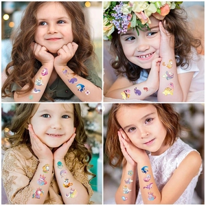 Detail showing colorful dinosaur and unicorn temporary tattoos on a child's arm