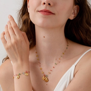 Gold-plated stainless steel jewelry set with colorful stones and starfish charms on model