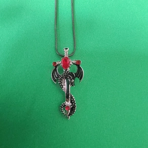 Vue détaillée du pendentif épée dragon vintage en argent serti de pierres rouges facettées