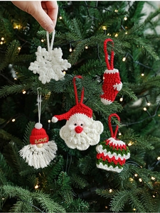 Handcrafted crochet Christmas ornaments including Santa and snowflake on a tree branch