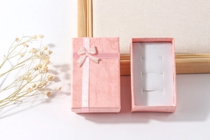 Pink paper jewelry gift box with ribbon bow and white sponge insert for rings