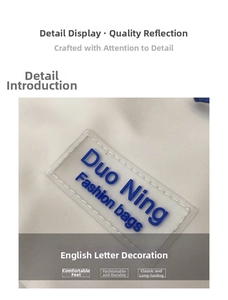 Macro shot of white nylon bag with transparent PVC logo patch and blue typography