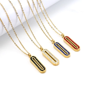 Détail de colliers dorés avec pendentifs ovales sertis de cristaux noirs, blancs, bleus et rouges