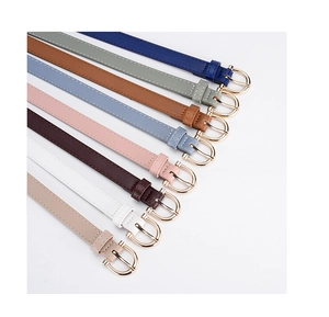 Detailed view of multiple slim PU leather belts for women with gold horseshoe buckles