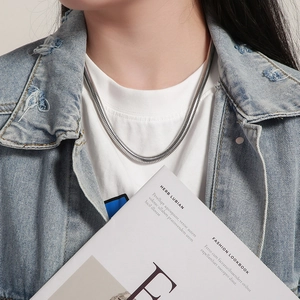Polished 304 stainless steel snake bone chain necklace on model wearing denim jacket