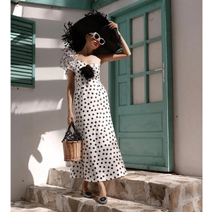 Detail of ruffle shoulder design on polka dot one-piece swimsuit for beach vacation