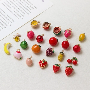 Flat lay of colorful enamel fruit charms including strawberry and cherry for DIY jewelry