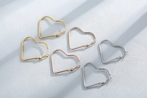 Detailed view of heart-shaped hoop earrings in gold, silver, and rose gold with spiral texture