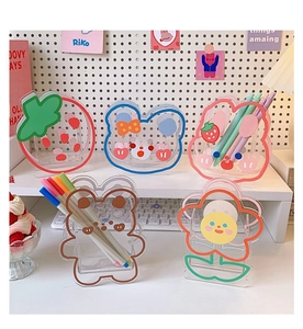 Detailed view of clear acrylic pen holders with cute cartoon bear and strawberry motifs