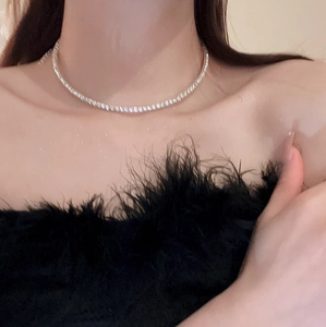 Close-up of elegant silver tennis necklace with shimmering zircons on a model's neck