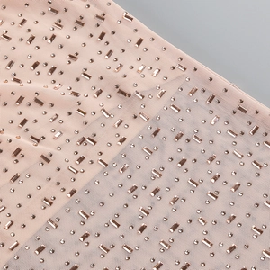Gros plan de strass et cristaux sur tissu mesh couleur chair pour robe de soirée