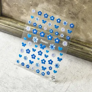 Detail of 5D embossed nail stickers featuring blue floral, bow, and heart designs