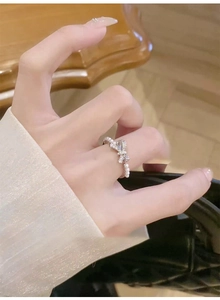 Detailed close-up of a zircon bow ring with elegant white pearls on a model's hand