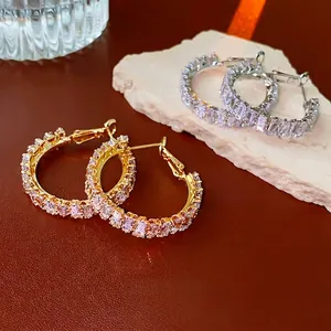 Gold and silver C-shaped hoop earrings with baguette-cut cubic zirconia on stone base