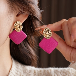 Detail shot of irregular gold hammered metal and purple leather geometric earrings
