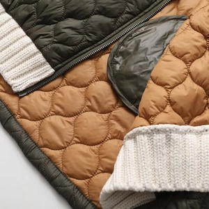Detailed close-up of diamond quilted nylon fabric with olive and caramel color stitching