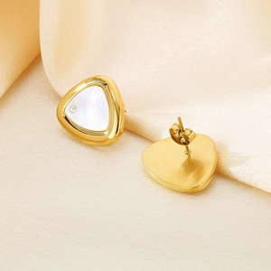 Close-up of triangle stud earrings with white shell inlay and gold finish on silk fabric