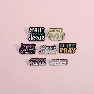 Detail of colorful religious enamel pins with motivational quotes on a pink background