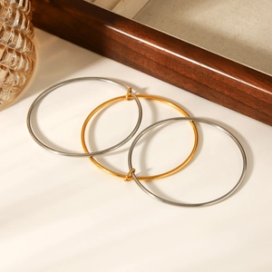 Detailed macro view of high-polished gold and silver stainless steel bangles set