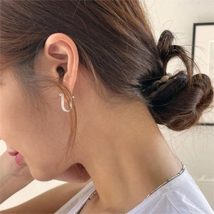 Minimalist 925 sterling silver U-shaped horseshoe stud earrings worn by a model