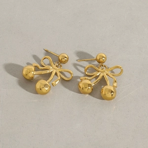 Nahaufnahme goldener Kirsch-Ohrringe mit Schleifen-Design und gehämmerter Metallstruktur