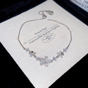 Detail of adjustable flower bracelet with opal cat eye stone and cubic zirconia accents