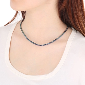 Close-up of rainbow braided stainless steel basket chain necklace on a model's neck
