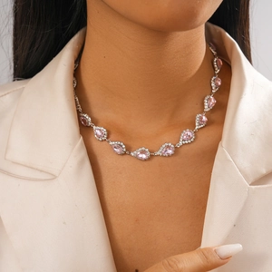 Détail du collier à pendentif goutte rose avec cristaux sur mannequin pour un look chic