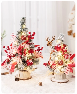 Detail of mini flocked Christmas tree with red berries, LED lights and burlap base