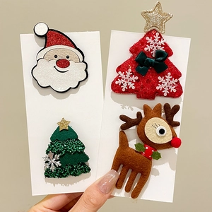 Hand holding cute Christmas felt hair clips set featuring Santa, tree, and reindeer shapes