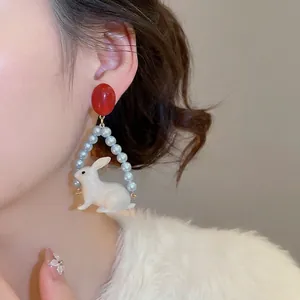Boucles d'oreilles lapin élégantes avec clous rouges et cadre de perles bleues