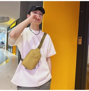 Street style view of a mustard yellow crossbody chest bag with adjustable green strap