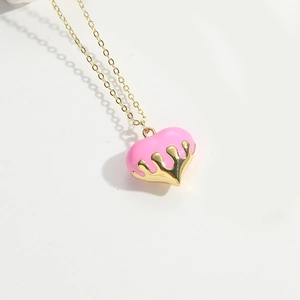 Detailed view of the pink peach heart pendant with a liquid glaze finish and gold chain