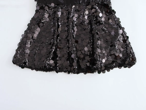 Detailed view of shimmering black sequins and smooth fabric texture on the mini skirt