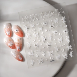 Détail de stickers à ongles papillon 3D avec perles gaufrées sur des ongles dégradés