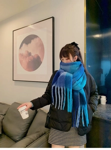 Detail of blue gradient plaid scarf with long fringe tassels and soft winter texture