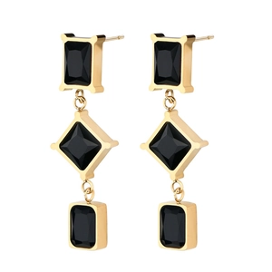 Detailed view of geometric drop earrings with gold metal and black faceted stones
